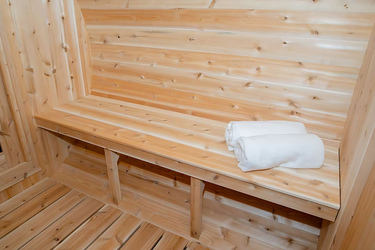 Warm cedar barrel sauna interior with rolled towels